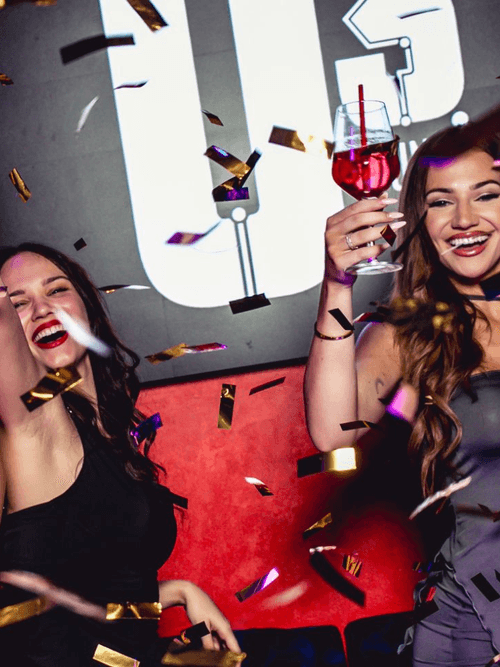 Drei feiernde Frauen im Confetti-Regen